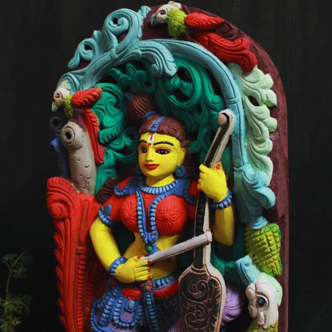 handmade and hand painted madanika wooden artifact playing violin and a bird is watching her