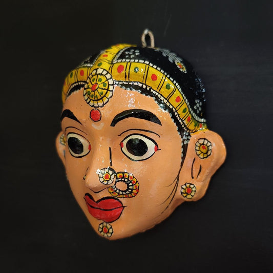 classic female cheriyal mask with crayola peach color face wearing ornaments