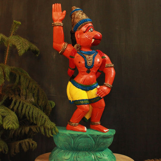 hand crafted wooden artifact of lord hanuman in orange color and in a stance of aggressiveness